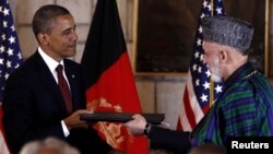 Afghan President Hamid Karzai (right) and his U.S. counterpart Barack Obama exchange documents after signing a Strategic Partnership Agreement at the Presidential Palace in Kabul on May 2.