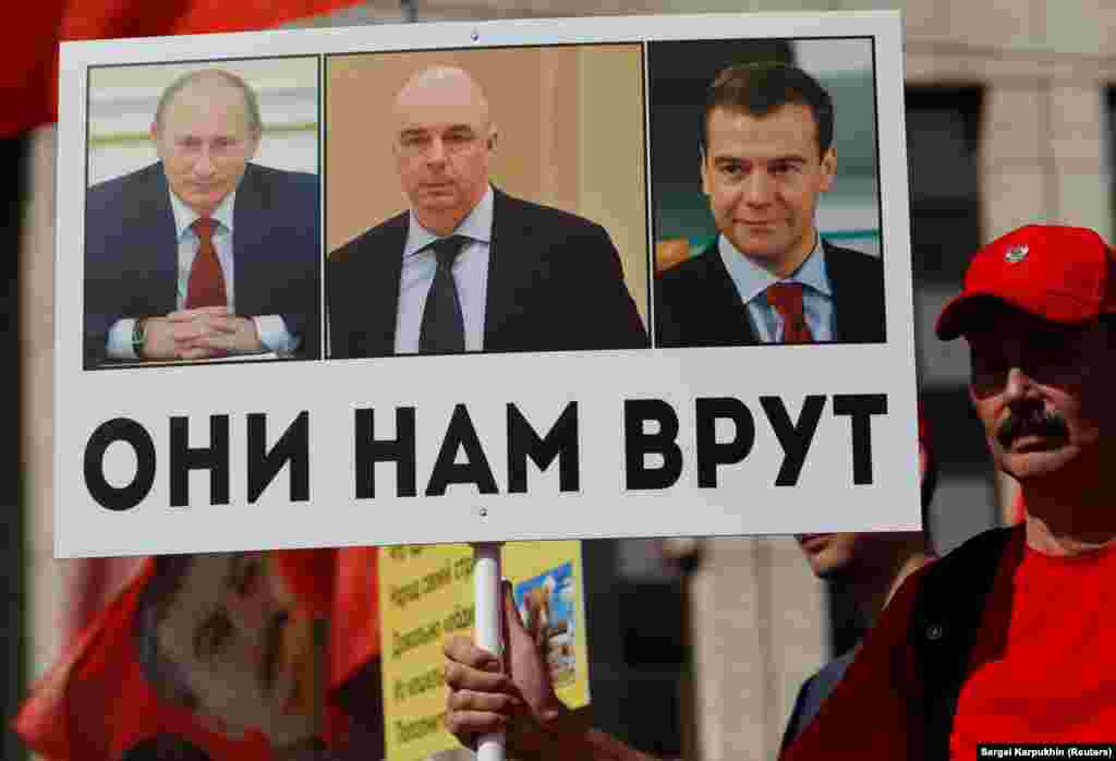 At a September 2, 2018, protest against a proposed increase to the retirement age, an activist's sign shows Putin, Medvedev, and Finance Minister Anton Siluanov with the slogan "They lie to us." 