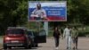 People walk near a banner in support of the Russian Army in Vyborg, Russia.