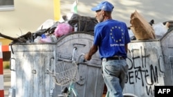 Macedonia -- A man wearing a tee-shirt with the European Union logo collects plastic bottles from trash-containers in the centre of Skopje, 24Jun2013