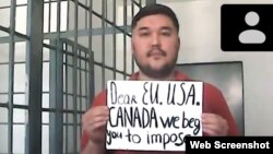 Сотта ағылшынша "Құрметті Еуроодақ, АҚШ, Канада, сіздерден [шара қабылдауды] сұраймыз" деп жазылған қағаз ұстап тұрған белсенді Қайрат Қылышев. Алматы, 28 қыркүйек 2021 жыл.