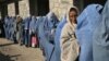 Afghan widows queue in front of an aid agency office for their monthly ration in Kabul prior to the Taliban takeover. Nearly all international aid has since dried up.