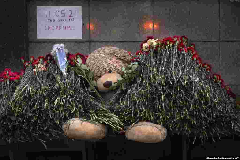 A teddy bear and flowers with the poster reading &quot;11.05.21, School # 175, Mourn&quot; in memory of the slain students in Kazan at the Tatarstan region&#39;s office in Moscow.