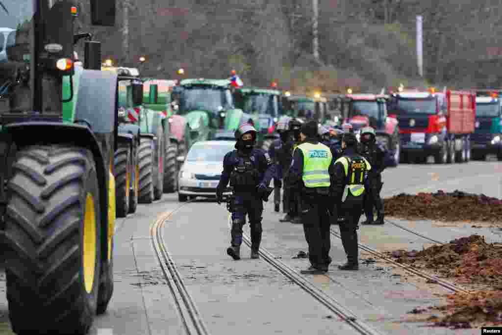 Police in Prague, the Czech Republic, seen alongside piles of manure dumped outside government offices by protesting farmers on March 7. Along with ongoing protests in the Czech Republic, farmers surrounded the European Council building in Brussels in February, and thousands of German farmers shut down major roadways in January.