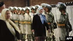 O femeie de etnie uiguri discută cu soldații chinezi, iulie 2009