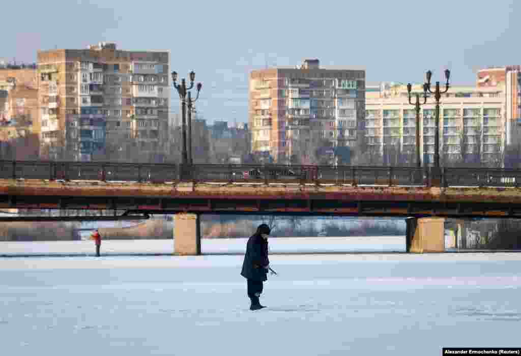  A man fishes on the ice-covered Kalmius River in Donetsk, a city in the east of Ukraine controlled by Russia-backed separatists, on January 26. 