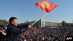 A protester in Bishkek waves the Kyrgyz flag at a rally earlier this week against disputed parliamentary election results. 