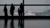 Пассажиры смотрят на самолеты компании Malaysia Airlines на взлетной полосе аэропорта в Куала-Лумпуре. 13 марта 2014 года. 