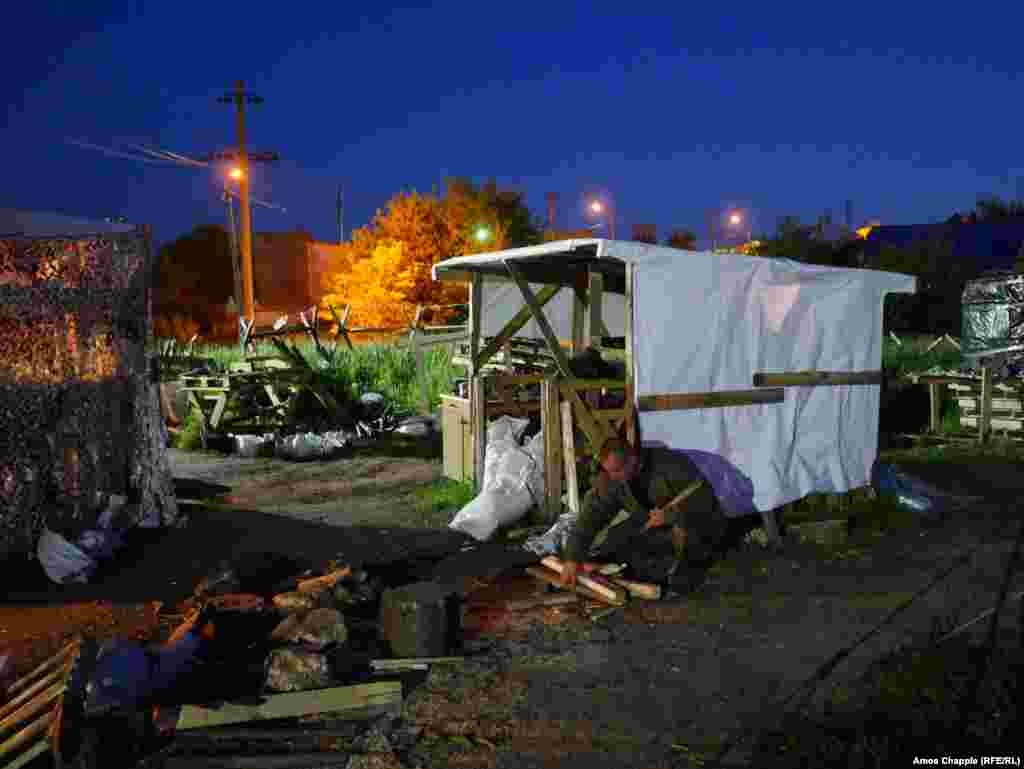 A blockader gathering firewood for the main sleeping tent. The activists declined to reveal details of the coming action, but the leader of the activists told a press conference they would target Russian-owned businesses in "a way no one expects." 