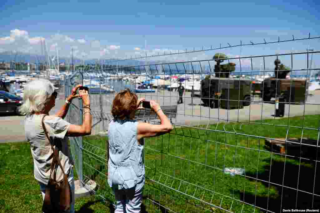 People take photos of a Swiss military radar system set up on the shore of Lake Geneva on June 11. 