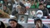 Members of Pakistan's Shi'ite Hazara community gather around the coffins of victims on January 8 to mark the fifth day of protest in the outskirts of Quetta.
