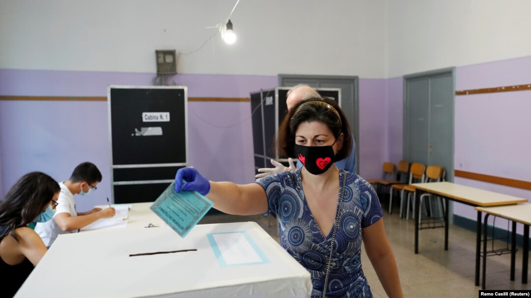 Rim - Žena ubacuje glasački listić na referendumu o prijedlogu za ustavne promjene koje podrazumijevaju smanjenje broja poslanika u italijanskom parlamentu, 20. septembar 2020.