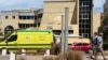 People walk next to an ambulance in front of the hospital in Egypt where the bodies of Russian tourists killed in the submarine incident are kept. 