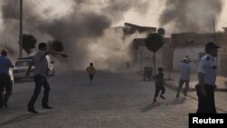 Smoke rises over the streets after a mortar shell landed from Syria in the border village of Akcakale on October 3.