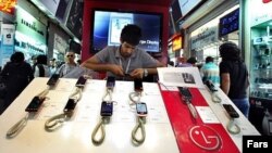 A shopkeeper adjusts mobile-phone handsets at a shopping center in Tehran. (file photo)