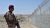 A Pakistani Army soldier stands guard along a border fence at the Afghan border near the Punjpai area of Quetta in Balochistan Province.