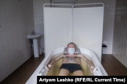 Viktor soaks in a medicinal bath.