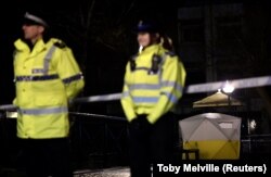 Police officers stand guard beside a cordoned-off area in Salisbury where Sergei Skripal and his daughter were found unconscious on March 4