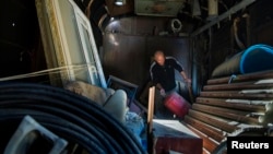 Aleksei Kravets rummages through belongings he saved from his house after being forcibly evicted in the course of construction work ahead of the 2014 Winter Games in Sochi.