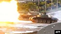 An image grab taken from a video uploaded to YouTube on February 10 purportedly shows a tank firing in the Baba Amro neighborhood in Homs on February 10.