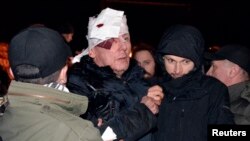 Iuri Luțenko primind ajutor medical după ce a fost lovit de poliție în seara de vineri 10 ianuarie, 2014