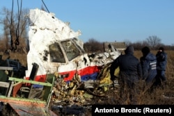 Local workers transport a piece of wreckage from Malaysia Airlines flight MH17 at the site of the plane crash near the village of Hrabove, in Ukraine's Donetsk region, in November 2014.