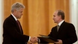Russian President Vladimir Putin (right) and US President Bill Clinton exchange agreements on the establishment of a joint warning center for the exchange of information on missile launches shortly after signing them, in Moscow on June 4, 2000.