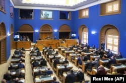 Volodomir Zelenszkij ukrán elnök videókapcsolaton keresztül szólal fel az észt parlamentben 2022. április 13-án.