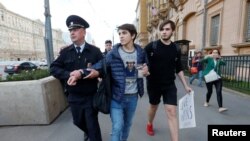 A Russian police officer detains a man as he attempted to place a candle for the victims of the shooting at a gay nightclub in Orlando in front of the U.S. Embassy in Moscow in June.