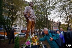 People lay flowers in front of a newly inaugurated statue of Markov in Sofia, Bulgaria, in November 2014.