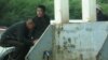 Оралманы сидят у городского рынка в Темиртау в ожидании предложений о поденной работе. 