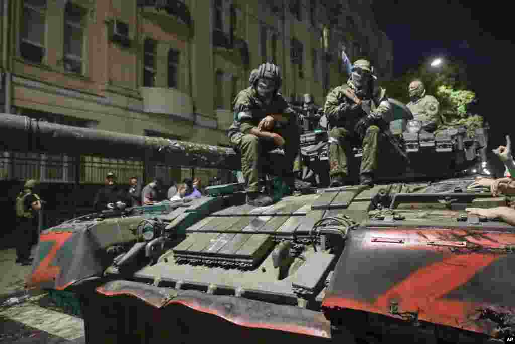 Members of Wagner sit atop a tank. 