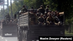 Kremlin-backed separatist fighters travel on trucks in Donetsk in July 2014.
