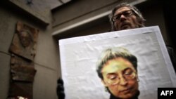 A man holds a portrait of Politkovskaya during a rally marking the 8th anniversary of her death in Moscow.