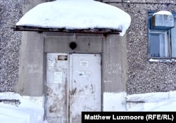 The words “section inhabited” are scrawled either side of the entrance to a mostly abandoned apartment block in Komsomolsky village.