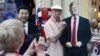 Un bărbat pozând cu imaginile lui Donald Trump și Xi Jinping la Moscova