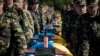 Ukrainian soldiers attend a mass funeral ceremony near Zaporizhzhya on October 1 to bury unidentified members of pro-Ukrainian military forces who were killed in fighting in the country's east.