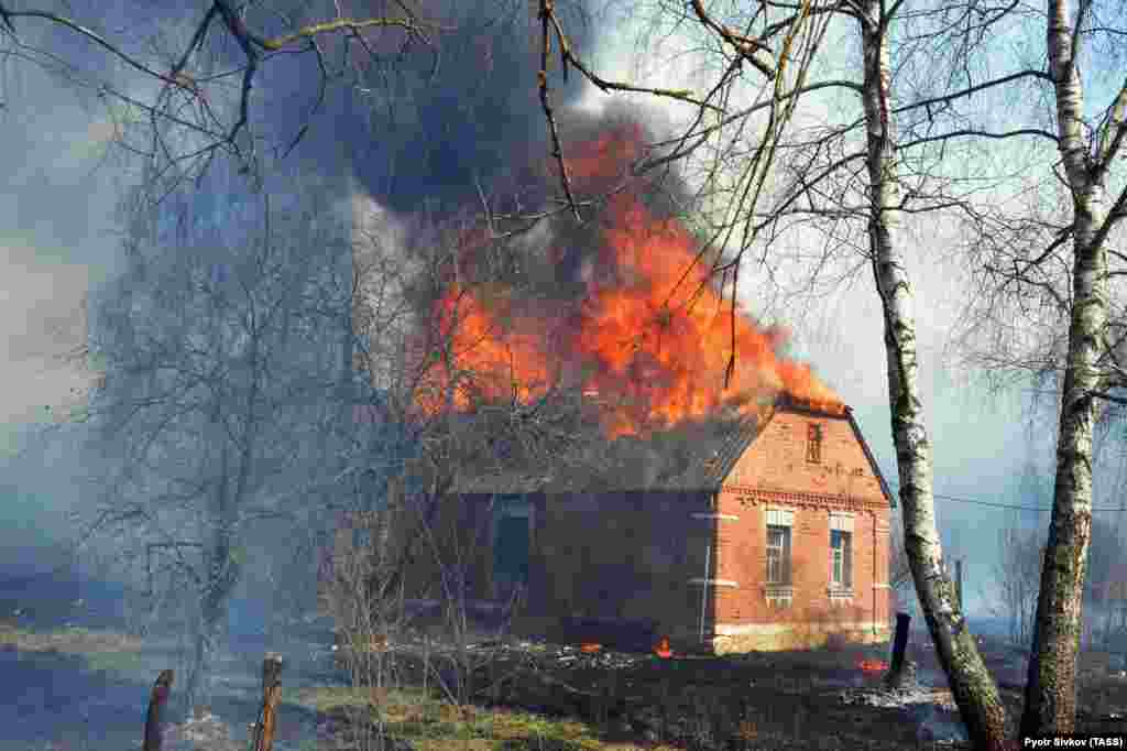 A house burns in the village of Stara Markivka, Poliske district, that was inhabited by squatters, in the exclusion zone on April 9. Many abandoned villages burnt down in the area.