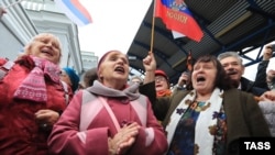 People celebrate the arrival of a passenger train from Russia in the Crimean city of Sevastopol on December 25. 