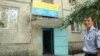 Участковый инспектор Сарсен Жунисбаев у подъезда в жилом доме, где находится полицейский участок. Алматы.