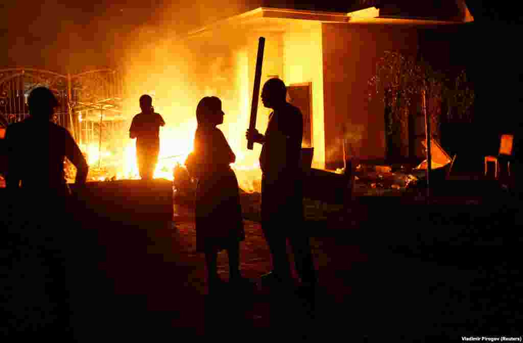 A fire rages in the compound as supporters of the ex-president arm themselves with sticks. 