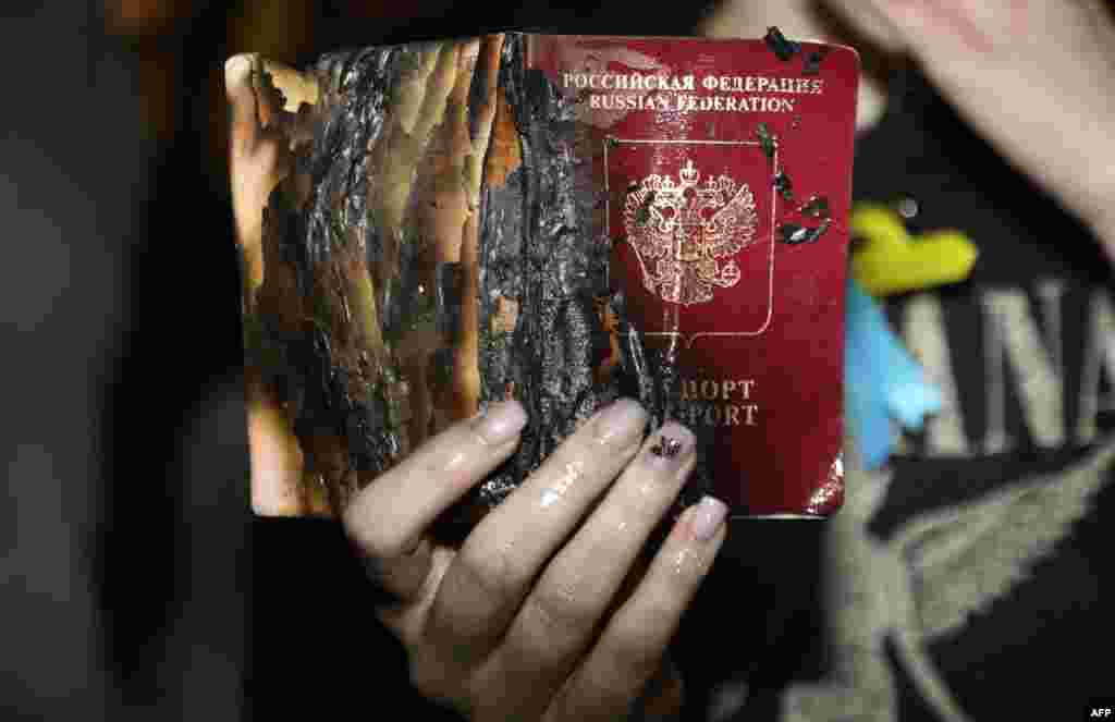 A demonstrator burns her Russian passport in front of the Russian Embassy in the Israeli coastal city of Tel Aviv on February 24.