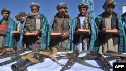 Сүрөттө: "Талибан" кыймылынын мурдагы мучөлөрү куралдарын таштап, Куранга кол коюп, ант беришүүдө