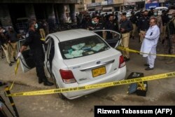 Investigators examine the scene where gunmen opened fire on two Chinese workers in Karachi in July 2021.