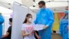 România: vaccinarea tinerilor de la 12 ani. Ana, în vârstă de 14 ani primește o diplomă de vaccinare anti Covid-19 de la șeful campaniei naționale de vaccinare, Valeriu Gheorghiță. 