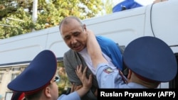 Kazakh law enforcement officers detain a participant at an opposition rally in Almaty late last year. 