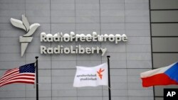 Azat Ýewropa/Azatlyk Radiosynyň Pragadaky baş binasynyň öňünde baýdaklar pasyrdaýar.