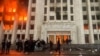 Protesters are seen on January 5 outside the Almaty mayor’s office, which was set ablaze during the protests.