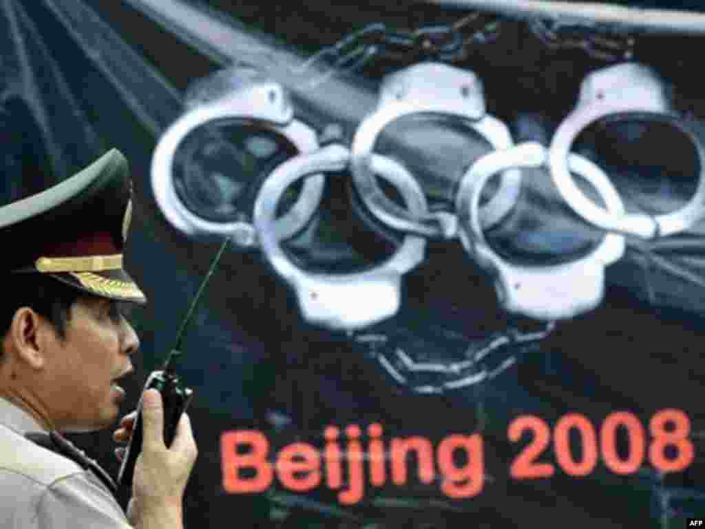 An Indonesian police officer stands beside an anti-Chinese banner during a demonstration organized by pro-Tibet activists and supporters during the Olympic torch's visit to Jakarta in April 2008.