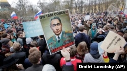 Protesters carry a poster depicting President Vladimir Putin as an elderly Soviet leader in St. Petersburg on May 5.